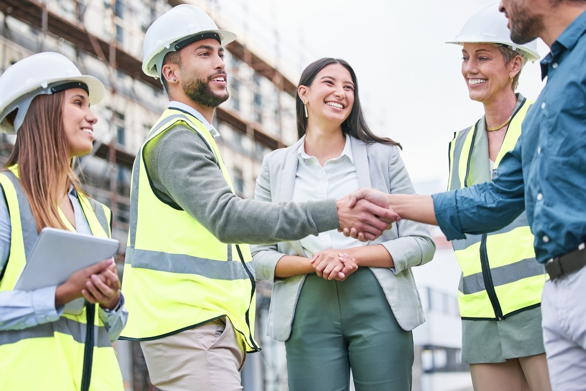 Shot of a team of builders shaking hands on a construction site outside